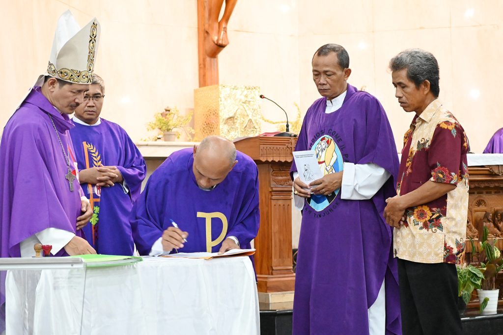 Romo Agusinus Triyono menandatangani SK di hadapan Uskup